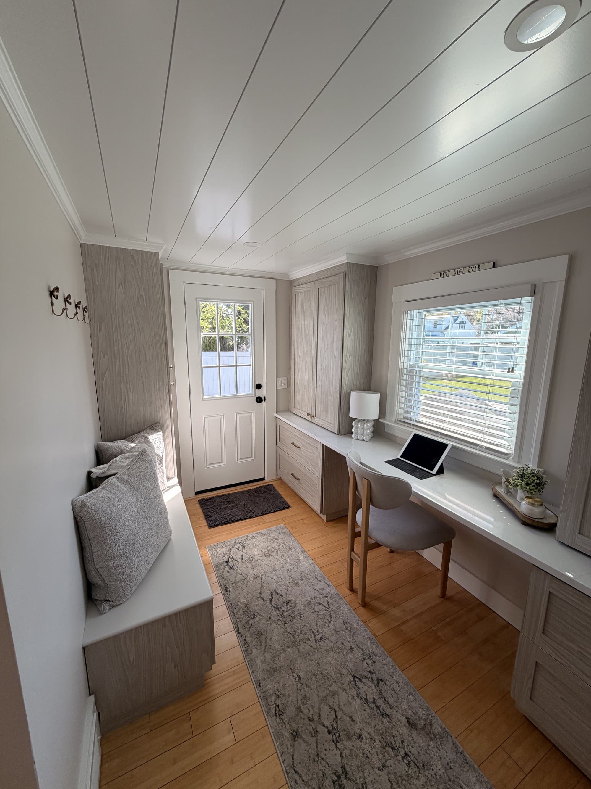 Renovated mudroom with new exterior door, custom built-ins, and refinished ceiling