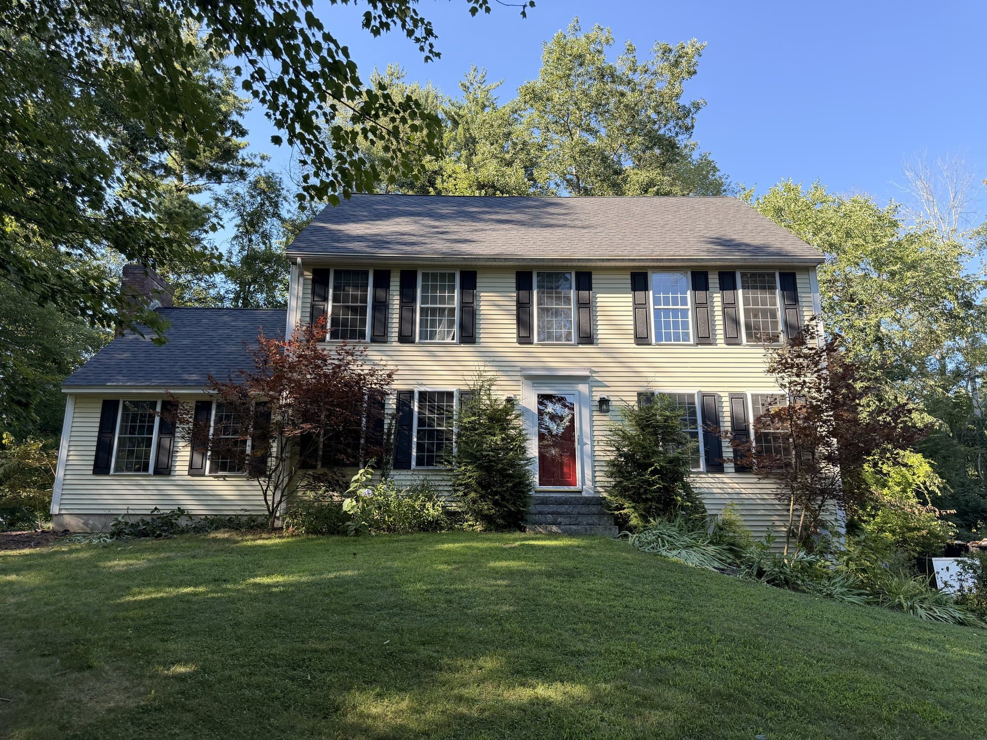 Front elevation of a yellow colonial in Kingston, NH with a new Dual Black asphalt shingle roof