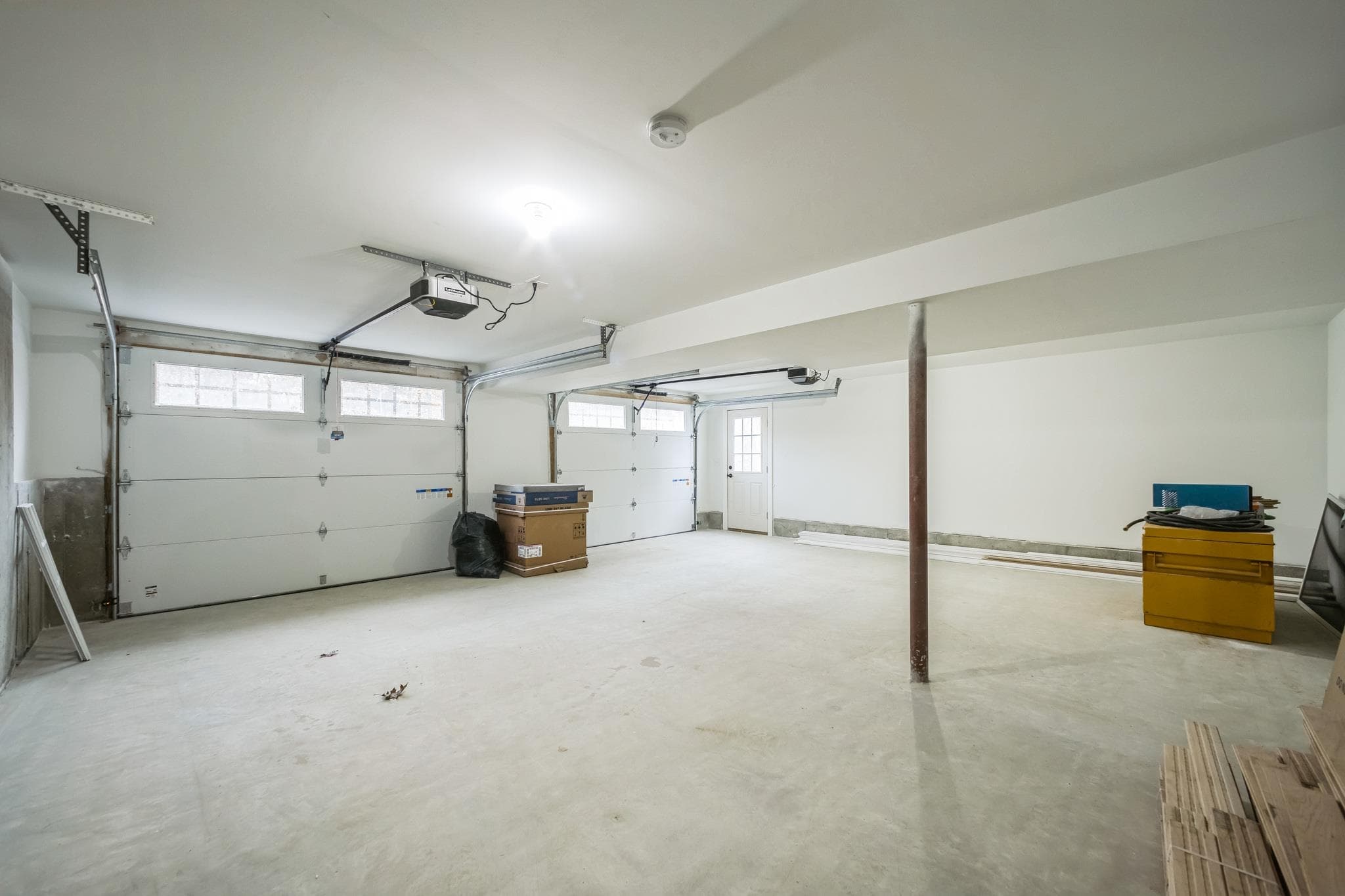 Two-car garage interior with finished walls and insulated doors